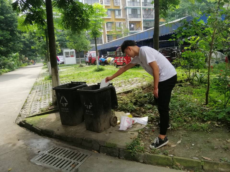 (图一为志愿者帮助捡拾社区垃圾)